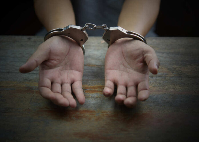 Close,Up,Of,Criminal,Hands,With,Handcuffs,In,The,Front.