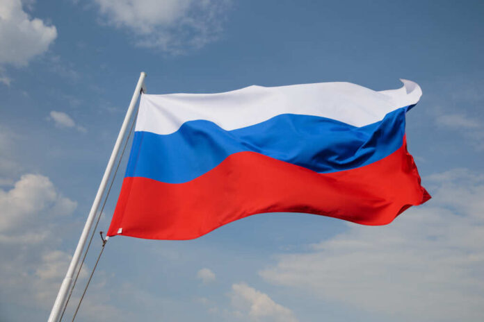 Russia,Flag,Is,Waving,In,Front,Of,Blue,Sky.