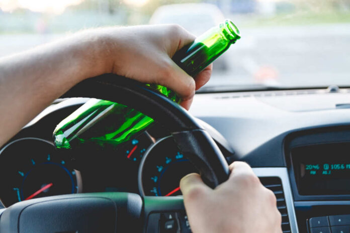 Drunk,Young,Man,Driving,A,Car,With,A,Bottle,Of