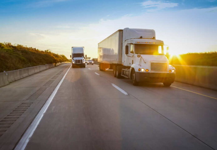 Old,Semi,Truck,On,Road,With,Sun,Flare