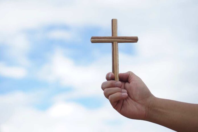 Closeup,Hand,Holds,Wooden,Cross.,Concept,,Christian,Worship.,Faith,,Forgiveness