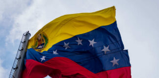 Venezuelan flag waving against a blue sky