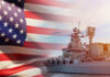A naval ship with the American flag in the foreground