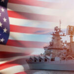 A naval ship with the American flag in the foreground