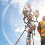 NASA’s Secret Weapon: ULIS Power Revolution Telecommunication worker in safety gear standing near a cell tower under a blue sky