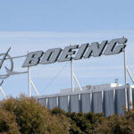 Astronauts Stranded: Boeing’s $4.2 Billion Blunder Boeing company sign displayed on a building against a clear blue sky