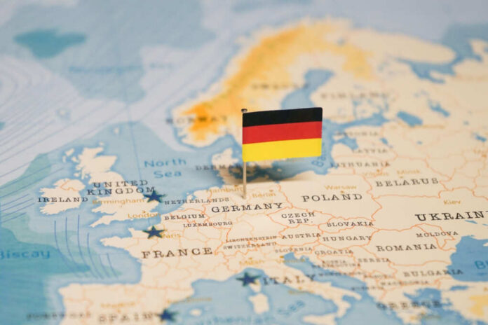 shutterstock_2324819755.jpg Map of Europe with a small German flag pin marking Germany