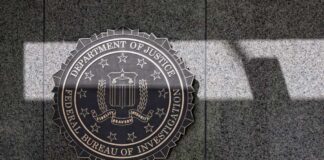 FBI seal mounted on a granite wall with shadows