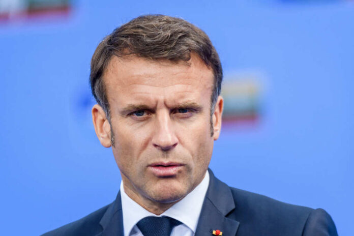 Close-up portrait of a serious-looking male political leader in formal attire against a blue background