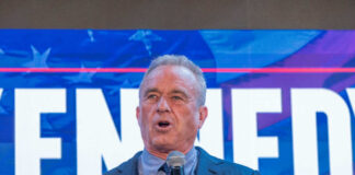A man speaking into a microphone at a political event