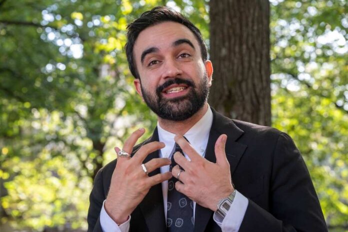 Man in business attire speaking outdoors with a natural background