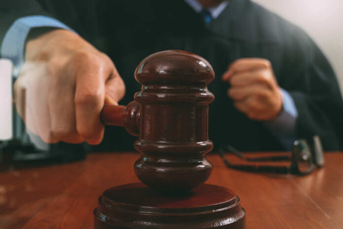 shutterstock_557953477.jpg A judge striking a gavel on a wooden desk