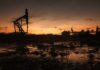 Silhouette of oil pumps against a sunset sky