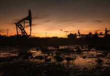 Silhouette of oil pumps against a sunset sky