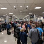 Crowd of travelers waiting in an airport terminal near boarding gates