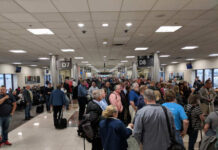 Crowd of travelers waiting in an airport terminal near boarding gates