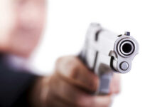 Close-up of a handgun pointed towards the viewer