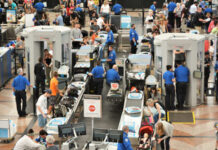 Busy airport security checkpoint with travelers and TSA agents