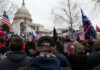 Crowd of protesters with American flags gathered in front of the Capitol building