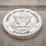 Seal of the United States Embassy displayed on a wall