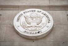 Seal of the United States Embassy displayed on a wall