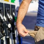 Person at a gas station showing empty pockets