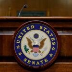 Close-up of the United States Senate seal on a wooden podium