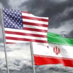 Unclear War Goals Stir Debate in Washington Flags of the United States and Iran waving against a cloudy sky