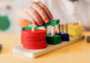 50% Of Kids Sneaky Daily: Parents Bewildered Childs hand stacking colorful wooden blocks