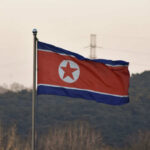 North Korean flag waving against a mountainous backdrop