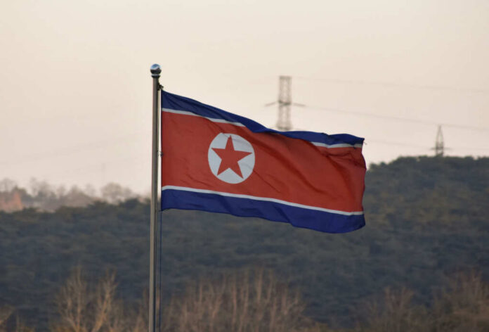 shutterstock_2511630583.jpg North Korean flag waving against a mountainous backdrop