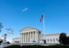 Mail-In Ballot Controversy Rocks 14 States U.S. Supreme Court building with American flag and blue sky