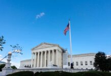 Mail-In Ballot Controversy Rocks 14 States U.S. Supreme Court building with American flag and blue sky
