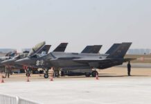 F-35 military jets parked on an airfield with crew members nearby