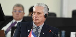 Cuban leader at a political meeting wearing headphones