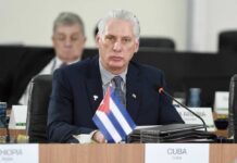 Cuba’s Unexpected Dialogue with Washington Cuban representative at a political meeting with a flag in front