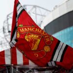 Manchester United flag waving in front of a stadium