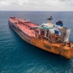 Aerial view of a large, rusty oil tanker in the ocean