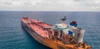 Aerial view of a large, rusty oil tanker in the ocean