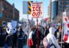 Crowd of protesters holding signs at a rally against ICE