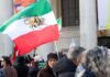 Crowd holding Iranian flags during a protest