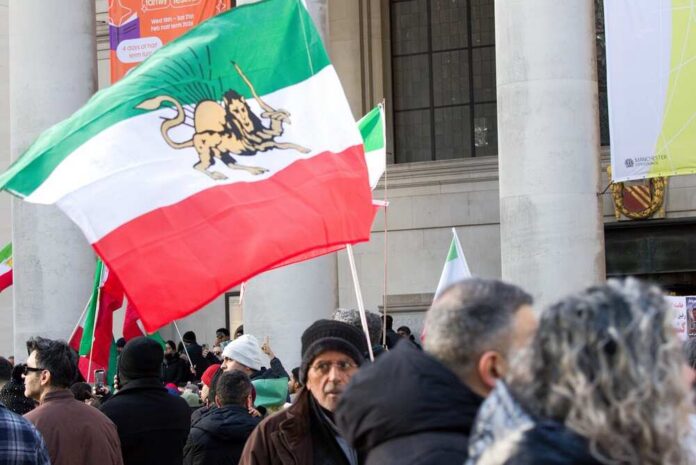 Crowd holding Iranian flags during a protest