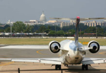 A private jet on the runway with the Capitol building in the background