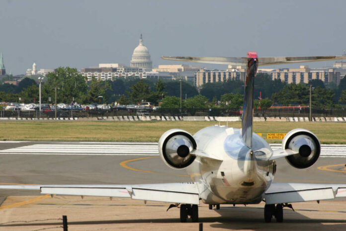 A private jet on the runway with the Capitol building in the background