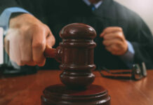 A judge striking a gavel on a wooden desk