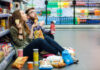 $21 Barbie Smoothie Sparks Consumer Outrage A young couple sitting on the floor of a grocery store enjoying snacks