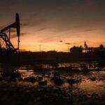 Silhouette of oil pumps against a sunset sky
