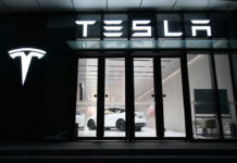 Tesla showroom featuring a white electric vehicle displayed under bright lights