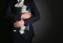 Businessman holding a briefcase filled with cash