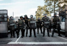 Law enforcement officers in riot gear standing in formation